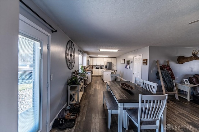 dining area featuring a textured ceiling and dark wood finished floors