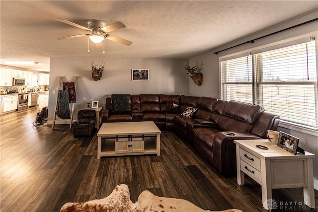 living room featuring a ceiling fan, dark wood-style flooring, and a textured ceiling