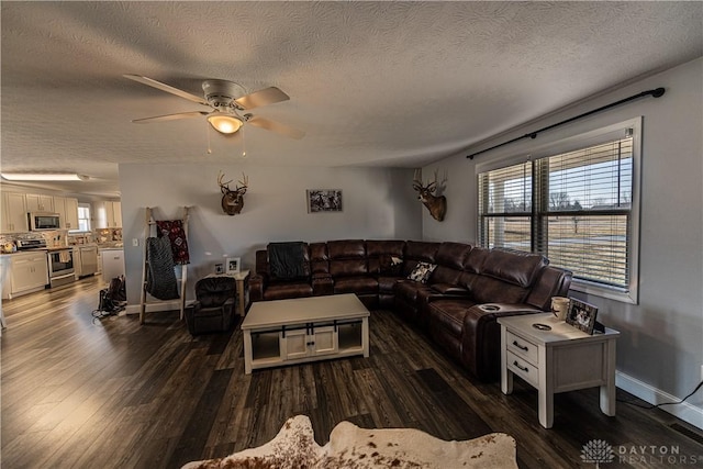 living room with dark wood-style floors, baseboards, ceiling fan, and a textured ceiling