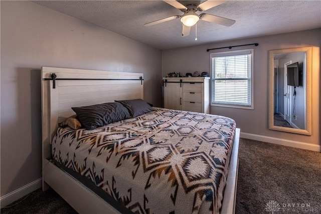 bedroom featuring dark colored carpet, a textured ceiling, ceiling fan, and baseboards