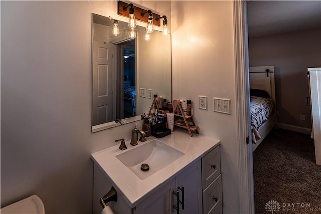bathroom with toilet, vanity, and ensuite bathroom