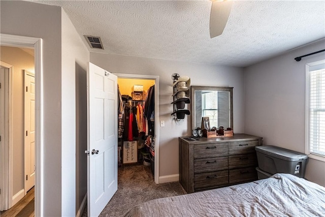 bedroom featuring a walk in closet, visible vents, multiple windows, and a closet