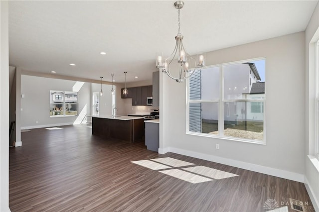 kitchen featuring an island with sink, light countertops, a chandelier, open floor plan, and visible vents