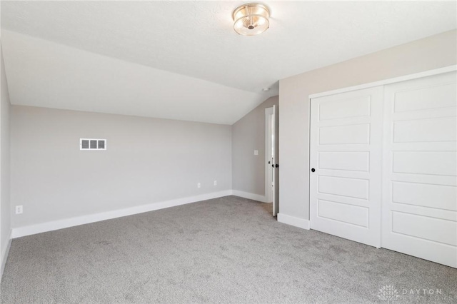 bonus room with baseboards, carpet, lofted ceiling, and visible vents