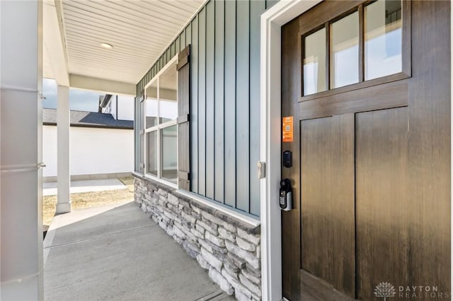 view of exterior entry featuring board and batten siding and a porch