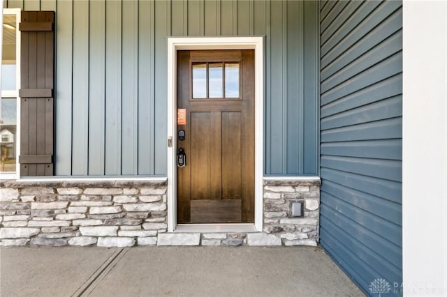 entrance to property with stone siding and board and batten siding