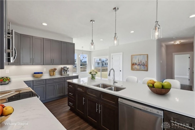 kitchen featuring dark wood-style floors, light countertops, a sink, and dishwasher