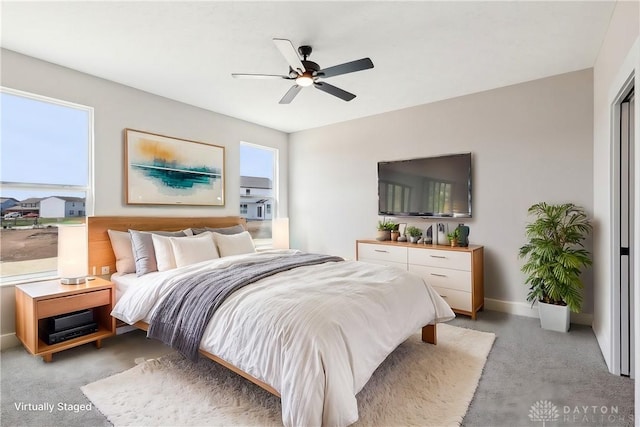 bedroom featuring baseboards, a ceiling fan, and light colored carpet