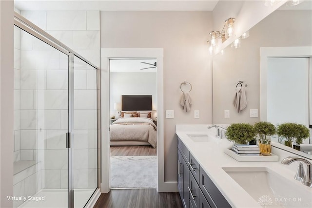 ensuite bathroom featuring ensuite bath, a sink, a shower stall, and wood finished floors