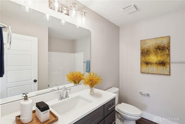 full bathroom with vanity, baseboards, toilet, and walk in shower