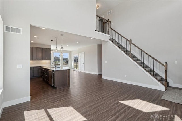 interior space with open floor plan, light countertops, baseboards, and visible vents