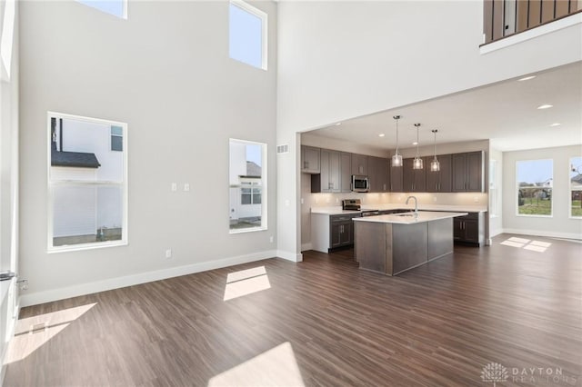 kitchen with dark wood-style floors, light countertops, baseboards, and appliances with stainless steel finishes