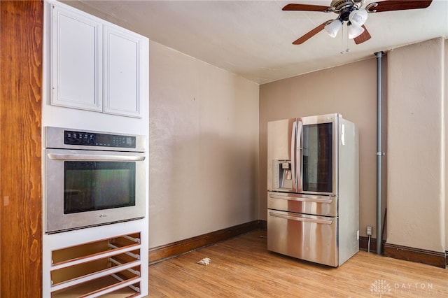531 W Ash St, Piqua, OH 45356 - kitchen featuring appliances with stainless steel finishes, light wood finished floors, white cabinetry, and a ceiling fan