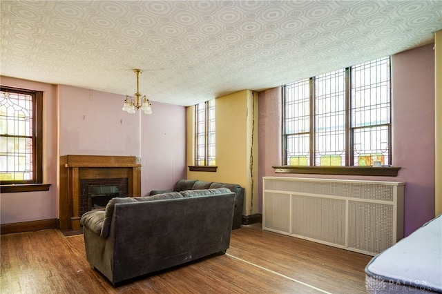 531 W Ash St, Piqua, OH 45356 - living area with radiator heating unit, wood finished floors, a chandelier, and healthy amount of natural light