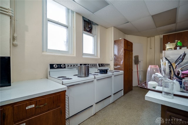 531 W Ash St, Piqua, OH 45356 - kitchen with white range with electric stovetop, light countertops, a drop ceiling, and light carpet