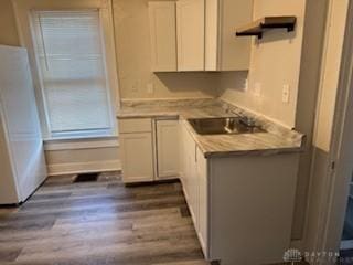 114 N Garland Ave, Dayton, OH 45403 - kitchen with light countertops, white cabinets, dark wood-type flooring, a sink, and freestanding refrigerator