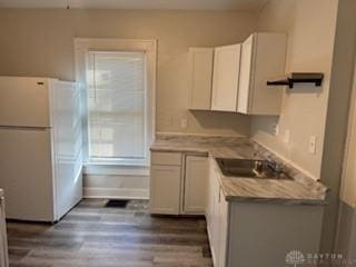 114 N Garland Ave, Dayton, OH 45403 - kitchen with light countertops, dark wood finished floors, white cabinetry, a sink, and freestanding refrigerator