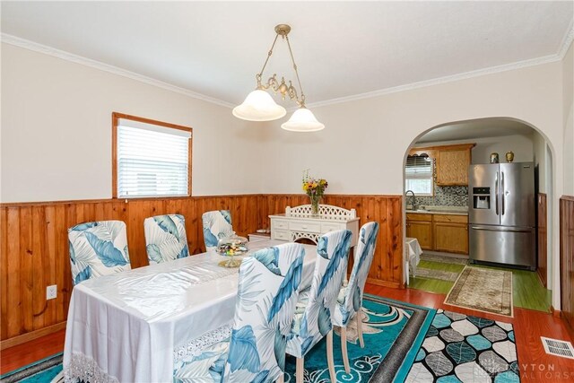 82 Notre Dame Ave, Dayton, OH 45404 - dining area with arched walkways, wood finished floors, a wainscoted wall, wood walls, and crown molding