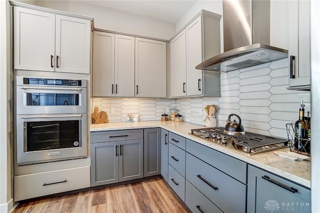 703 Doral Ct, Dayton, OH 45458 - kitchen with wall chimney range hood, appliances with stainless steel finishes, backsplash, and gray cabinets