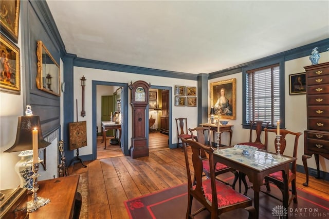 dining area featuring hardwood / wood-style flooring, baseboards, and crown molding