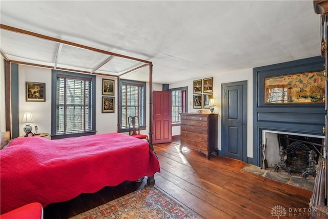bedroom with a fireplace and wood-type flooring