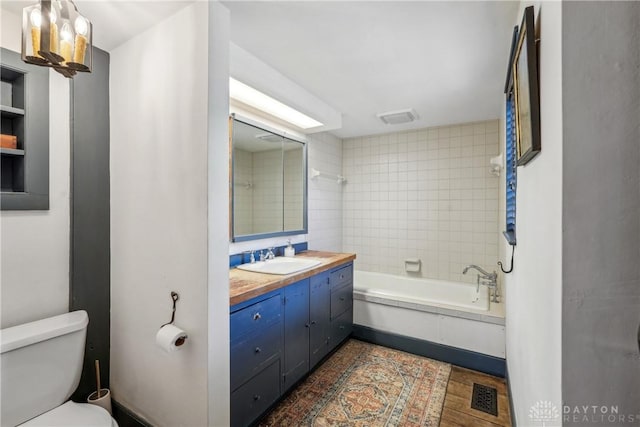 bathroom featuring visible vents, toilet, shower / bathing tub combination, and vanity
