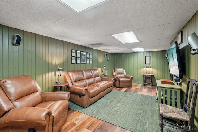 living room with visible vents, wood finished floors, and a paneled ceiling