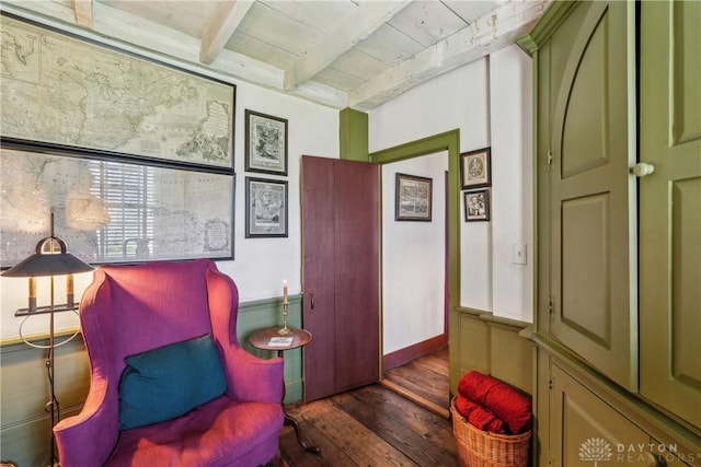 sitting room featuring beamed ceiling, wood finished floors, and wooden ceiling