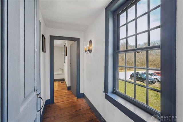 hall featuring baseboards and dark wood-type flooring