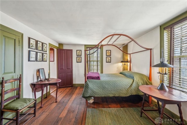bedroom with hardwood / wood-style floors and baseboards
