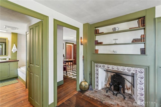 living area featuring a fireplace, built in shelves, and light wood-type flooring
