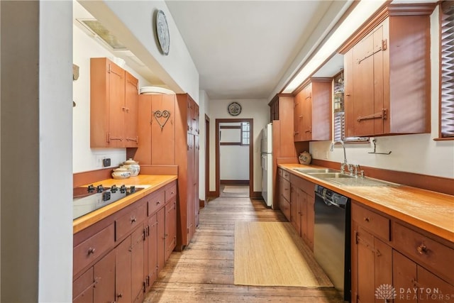 kitchen with light wood-style flooring, a sink, baseboards, and black appliances