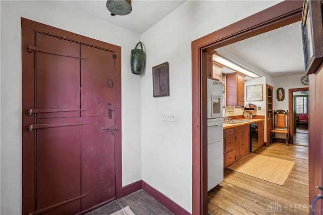 entryway featuring baseboards and light wood-type flooring