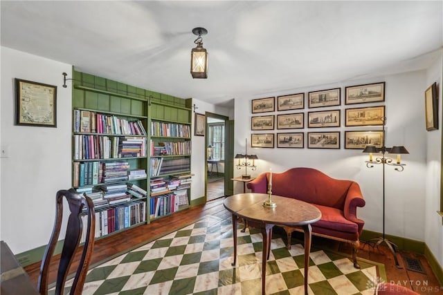 sitting room featuring baseboards, visible vents, and wood finished floors