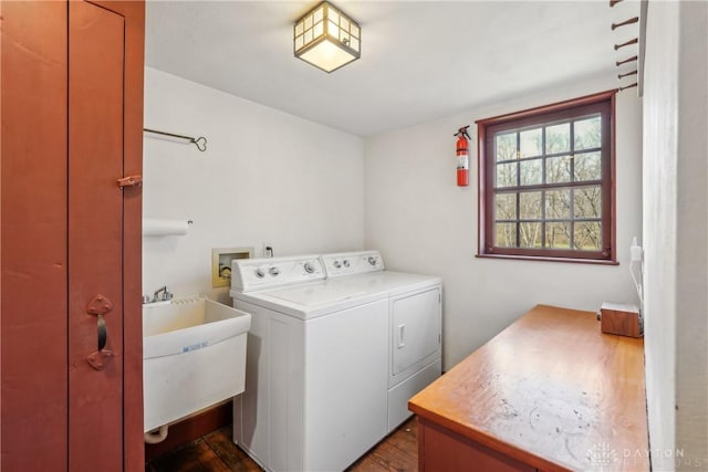 laundry room featuring washing machine and clothes dryer, cabinet space, and a sink