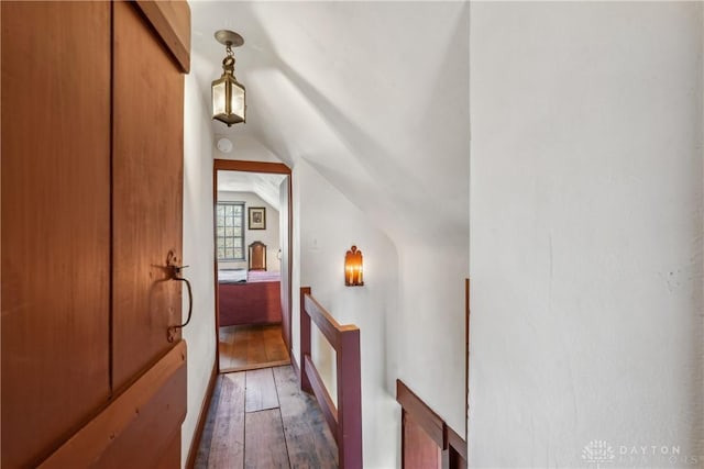 hall with lofted ceiling and hardwood / wood-style flooring