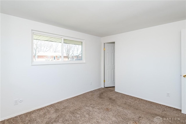unfurnished room featuring carpet flooring and baseboards