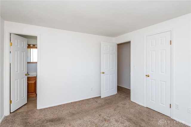 unfurnished bedroom with light carpet and ensuite bathroom