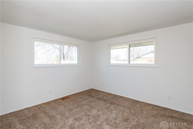 carpeted empty room with baseboards