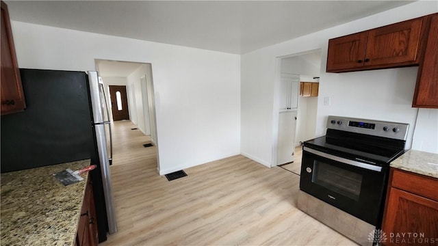 229 First, Piqua, OH 45356 - kitchen with range with electric stovetop, freestanding refrigerator, light wood finished floors, light stone counters, and baseboards