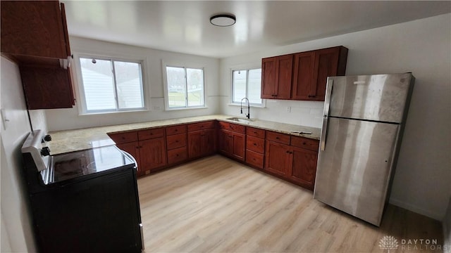 229 First, Piqua, OH 45356 - kitchen with freestanding refrigerator, a sink, black electric range, light wood finished floors, and light countertops