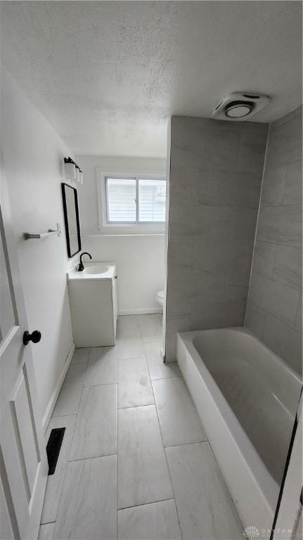 229 First, Piqua, OH 45356 - full bathroom with toilet, baseboards, a tub to relax in, vanity, and a textured ceiling