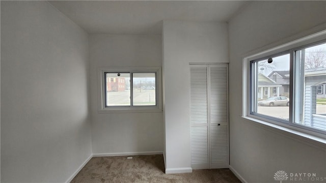 229 First, Piqua, OH 45356 - unfurnished bedroom with carpet, baseboards, multiple windows, and a closet