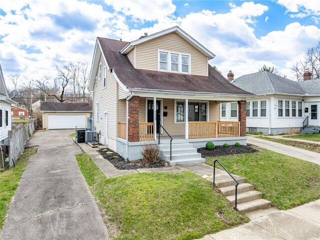 bungalow with an outbuilding, central air condition unit, a front lawn, a porch, and a garage