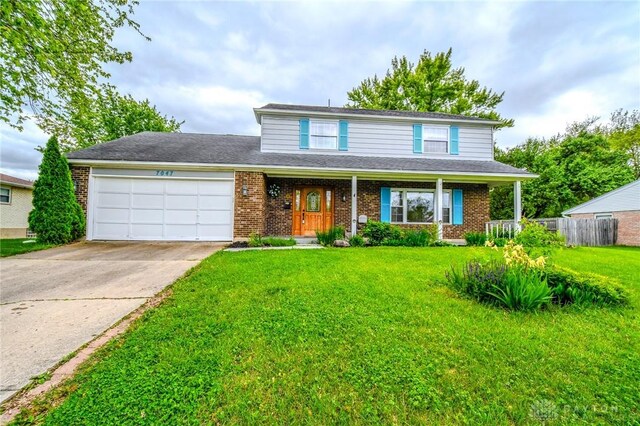 7047 Park Vista Rd, Englewood, OH 45322 - traditional home with a garage, brick siding, and concrete driveway