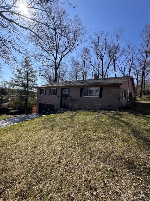 1314 Ridgeview Ave, Dayton, OH 45409 - view of front of home featuring asphalt driveway, a front yard, a chimney, and a garage