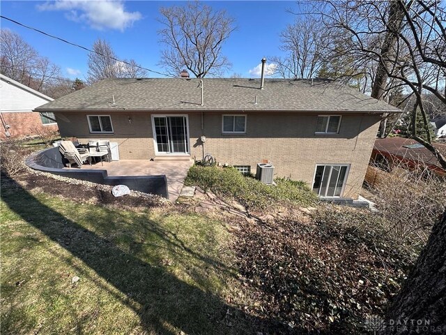 1314 Ridgeview Ave, Dayton, OH 45409 - back of house with brick siding, a patio area, a lawn, and roof with shingles