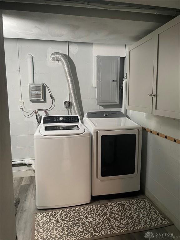 1314 Ridgeview Ave, Dayton, OH 45409 - laundry room featuring electric panel, washing machine and clothes dryer, concrete block wall, and wood finished floors