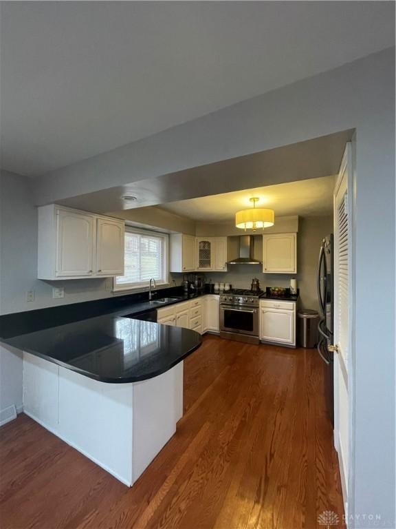 1314 Ridgeview Ave, Dayton, OH 45409 - kitchen featuring high end range, a peninsula, wall chimney exhaust hood, and dark wood-type flooring