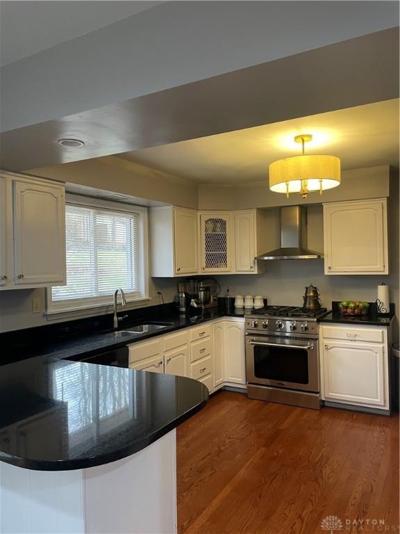 1314 Ridgeview Ave, Dayton, OH 45409 - kitchen featuring wall chimney range hood, stainless steel range, and white cabinets